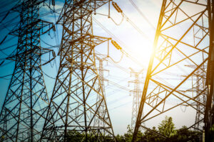 High-voltage transmission towers with electric power lines, representing the role of transformers vs. generators in power distribution